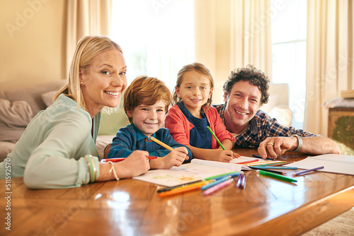 Were creating a masterpiece together. Portrait of a family drawing and colouring in pictures together at home.