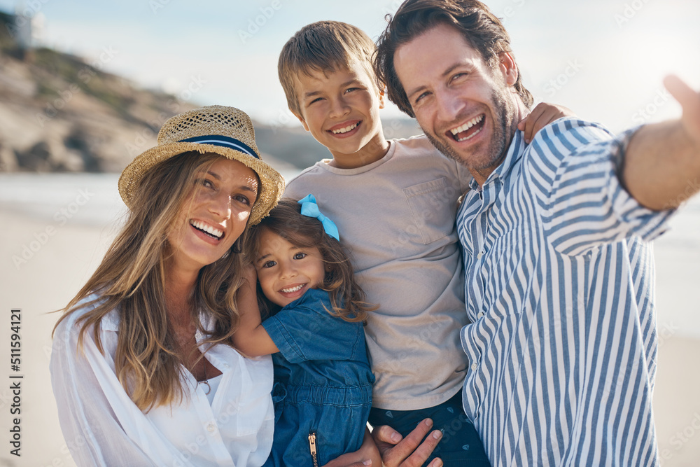 Smile for the camera kids. Cropped portrait of an affectionate couple carrying their two children and posing for a selfie on the beach. Smile for the camera kids. Cropped portrait of an affectionate couple carrying their two children and posing for a selfie on the beach.