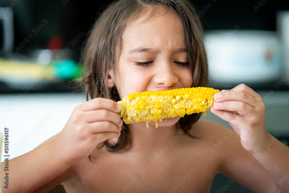 Summer snack, little boy sitting and eating corn High quality photo Summer snack, little boy sitting and eating corn High quality photo