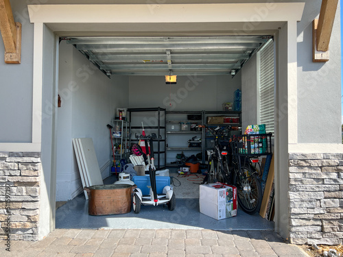 An unorganized garage filled with a lot of stuff in a neighborhood.