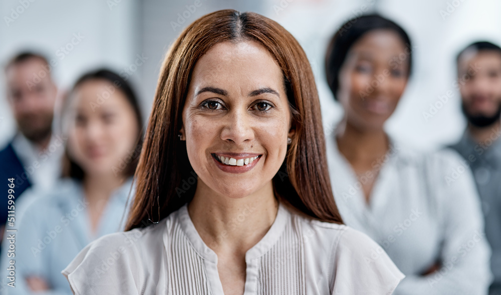 Im taking my team straight to the top. Portrait of a businesswoman standing in an office with her colleagues in the background. Im taking my team straight to the top. Portrait of a businesswoman standing in an office with her colleagues in the background.