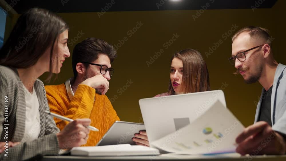 Office workers discuss start-up project in conference room with charts, laptop, tablet. Employees negotiate on meeting. Corporate people discuss plan, strategy, financials. Students talk in university Office workers discuss start-up project in conference room with charts, laptop, tablet. Employees negotiate on meeting. Corporate people discuss plan, strategy, financials. Students talk in university