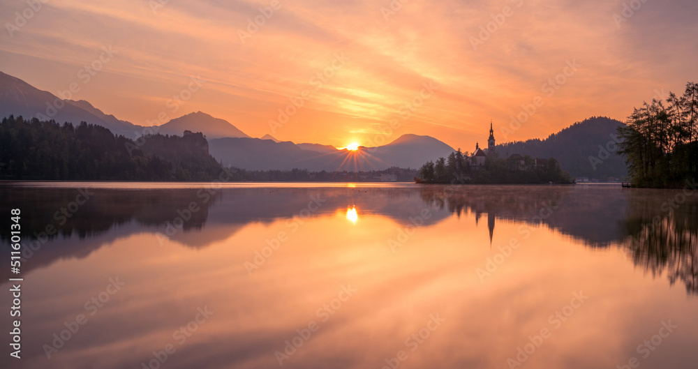Fototapeta premium Lake Bled on a fierce and vivid sunrise day