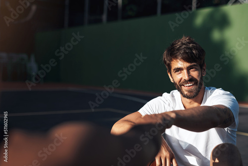 See you tomorrow, same time same place. Shot of a sporty young man giving his teammate a fist bump on a basketball court.