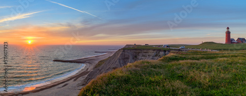 Panoramic view of the cliffs at the danish coast with the red lighthouse Bovbjerg Fyr. Panoramic view of beautiful nature landscape  at the Danish North Sea coast, Jutland, Denmark, Europe. photo