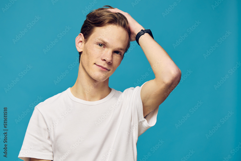 a guy in a white t-shirt stands on a white background holding his hand on his head a guy in a white t-shirt stands on a white background holding his hand on his head