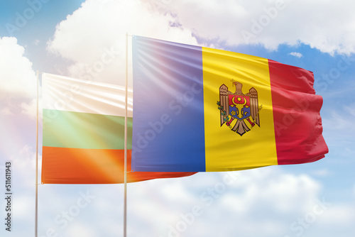 Sunny blue sky and flags of moldova and bulgaria