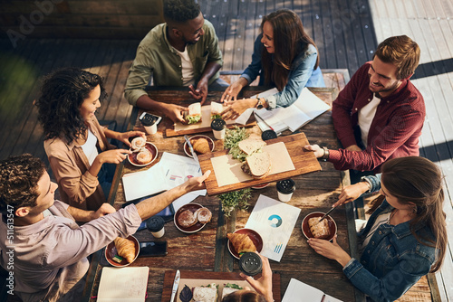 This lunch is bringing out the best in this meeting. Shot of a group of creative workers having a meeting over lunch in a cafe. photo