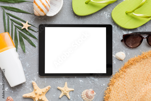 Flat lay composition with tablet and beach accessories on colored background. Tablet computer with blank screen mock up with copy space