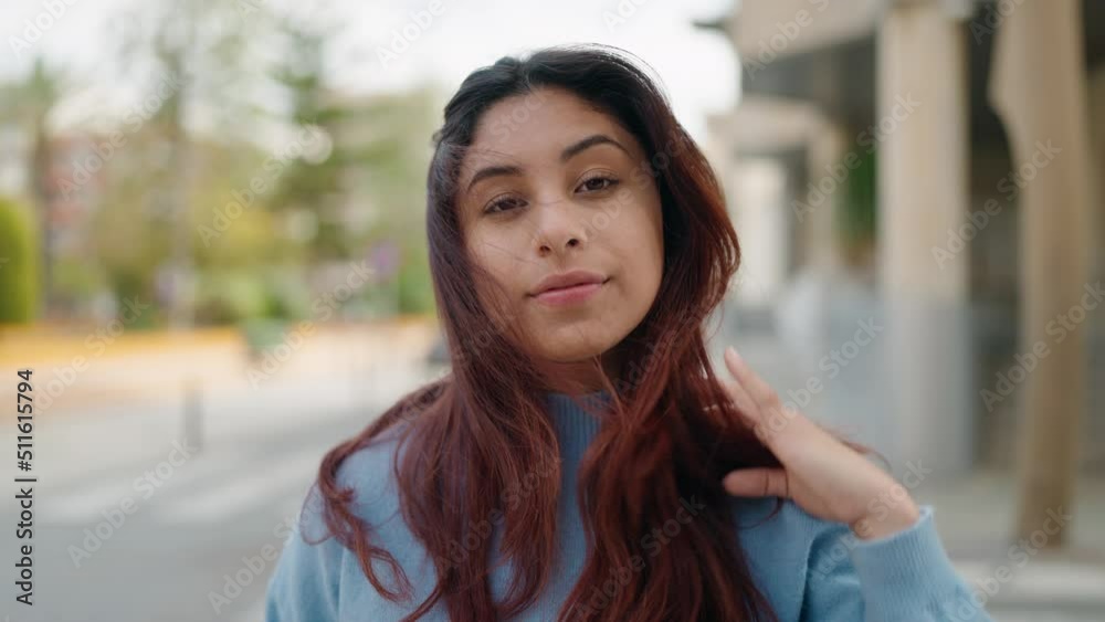 Young hispanic woman smiling confident combing hair with hands at street Young hispanic woman smiling confident combing hair with hands at street