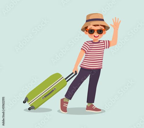 cute little boy wear hat and sun glasses pulling suitcase and waving hand go for travelling on summer vacation