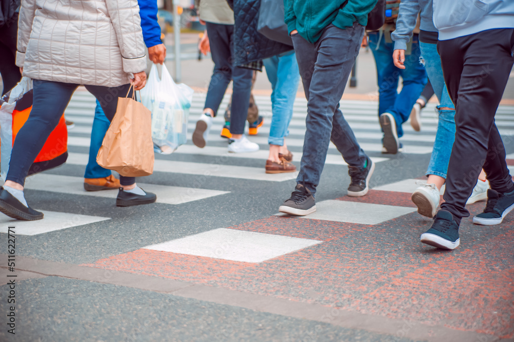 People crossing street in city, closeup view