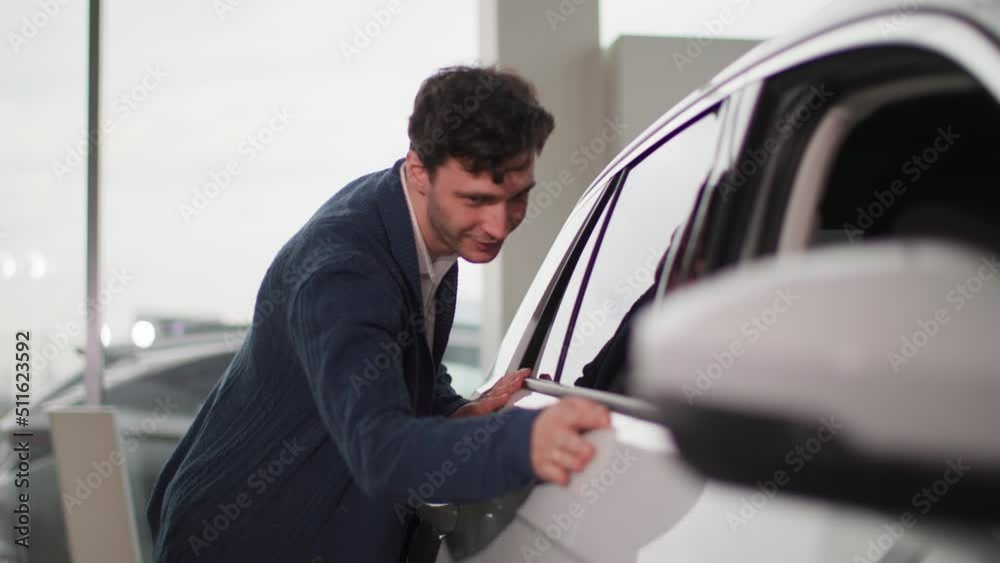 auto shop, charming owner looking at a new car with pleasure in a vehicle dealership auto shop, charming owner looking at a new car with pleasure in a vehicle dealership