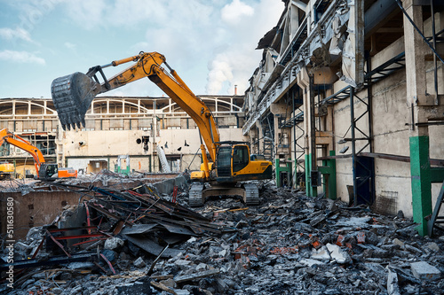 Hydraulic excavators at demolition site of industrial complex