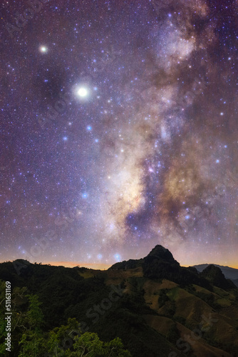 Milky Way galaxy with stars at night in mountain forest and sunrise.