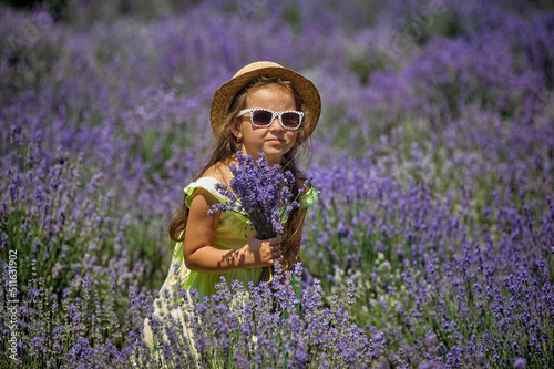 Obraz na płótnie Portrait of a little girl in lavender. Child in a straw hat and sunglasses in nature. w salonie