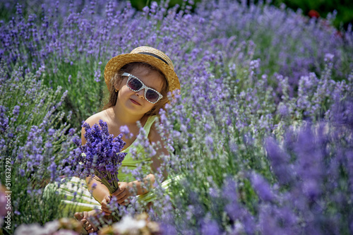 Obraz na płótnie Portrait of a little girl in lavender. Child in a straw hat and sunglasses in nature. w salonie