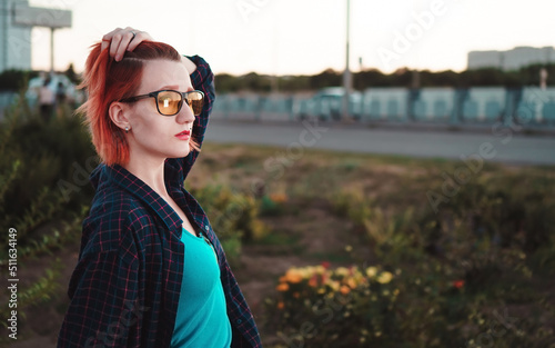 Woman with short ginger hair in urban environment. Sunset time.