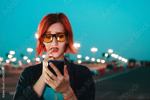 Woman reads bad news on smartphone. Illiterate investment concept, copy space.