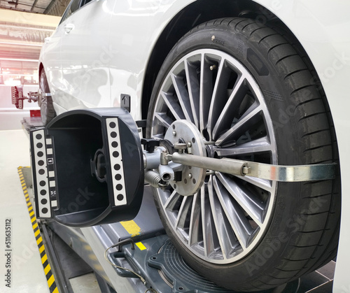A car on a stand with sensors on the rear wheels. For camber and Toe in angle adjustment wheel alignment check in the workshop of the service station.