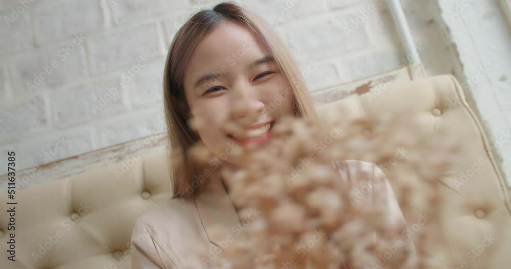 Attractive asian woman holds in hands a dry bouquet of flowers smiling to camera. Close up Face portrait of young beautiful charming female looking to camera. People casual leisure, Beauty lifestyle. Attractive asian woman holds in hands a dry bouquet of flowers smiling to camera. Close up Face portrait of young beautiful charming female looking to camera. People casual leisure, Beauty lifestyle.