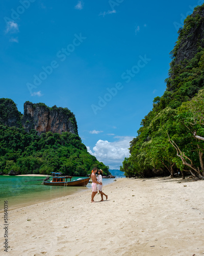 Koh Phakbia Island is near Koh Hong Krabi, a beautiful white sandy beach in Krabi Thailand. Young Asian woman and European men on the beach.  photo