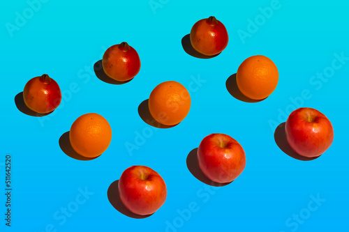 pomegranate, orange and apple isolated in color background