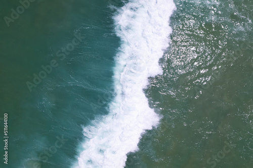 Sea blue surface aerial view.Top view blue water ocean waves with white foam background