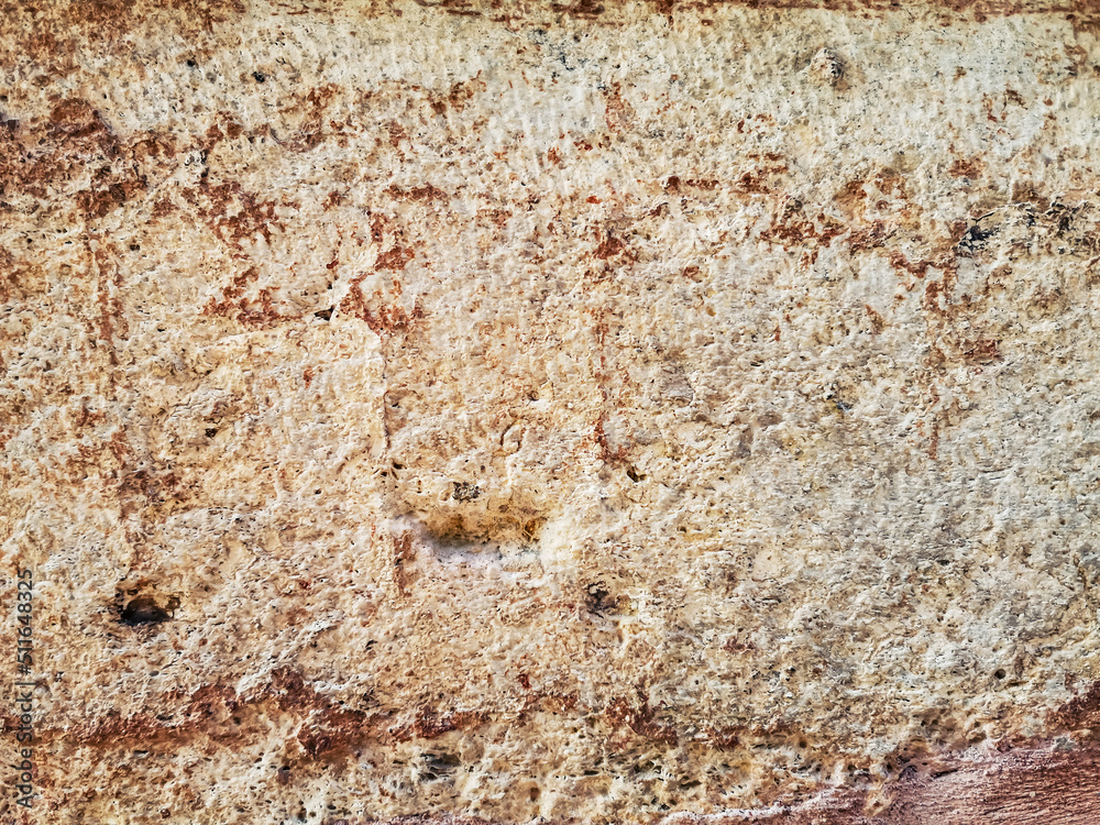 Light beige and brown porous limestone surface of an old stone wall. Beautiful grunge texture with roughness and scuffs in white, yellow and red shades Light beige and brown porous limestone surface of an old stone wall. Beautiful grunge texture with roughness and scuffs in white, yellow and red shades