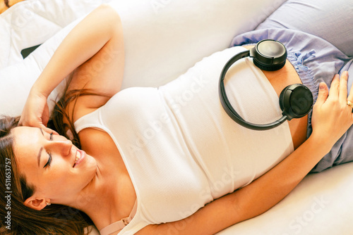 Pregnant woman music listen. Cheerful pregnancy girl relaxing listening music in headphones. Mother belly listen headphones sound. Pregnancy, medicine health care and people concept.
