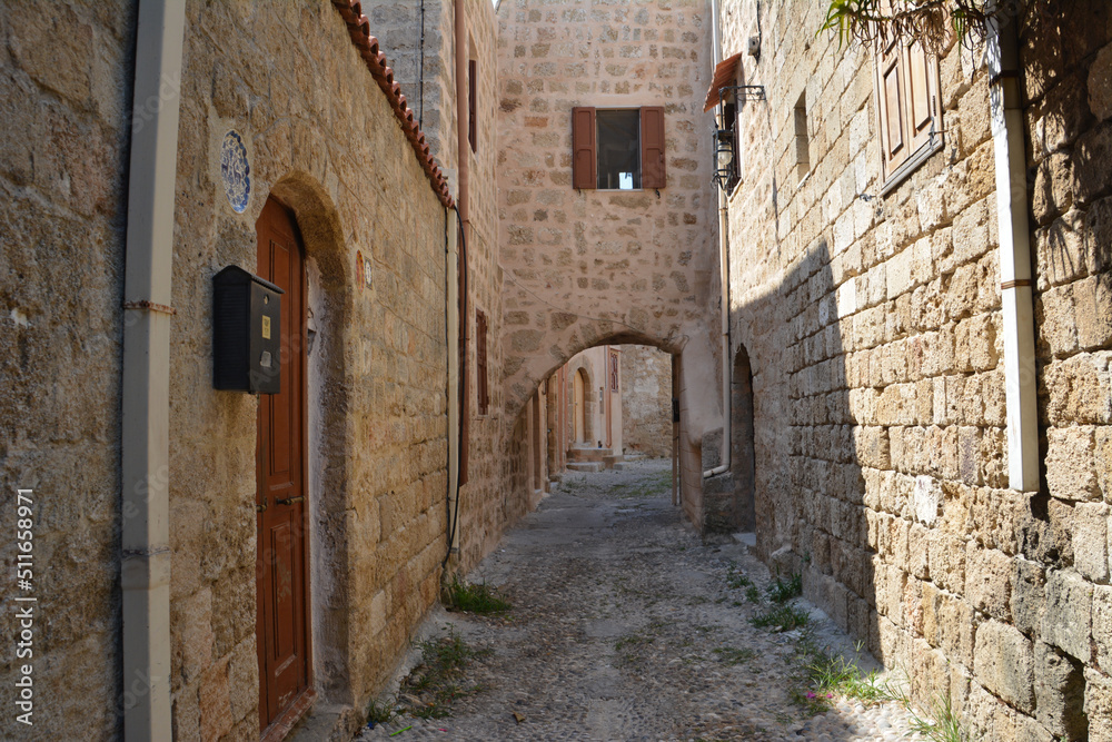 narrow medieval street with brick walls and arched doors and windows