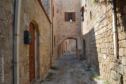 Fototapeta Naklejka Na Ścianę i Meble -  narrow medieval street with brick walls and arched doors and windows