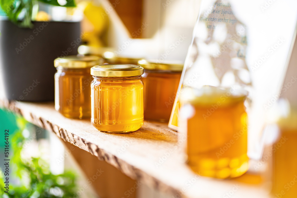 Natural honey in various jars on a wooden shelf, souvenir village market. Natural honey in various jars on a wooden shelf, souvenir village market.