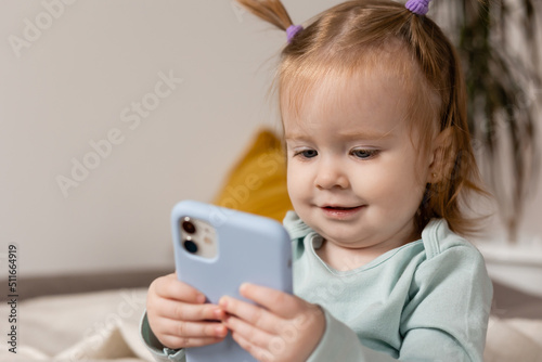 little girl is holding a smartphone in her hands. young blogger