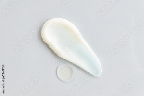 White cosmetic cream texture, skincare lotion swatch on gray background. Face creme, body moisturiser, hair conditioner smear smudge stroke. Creamy beauty product closeup