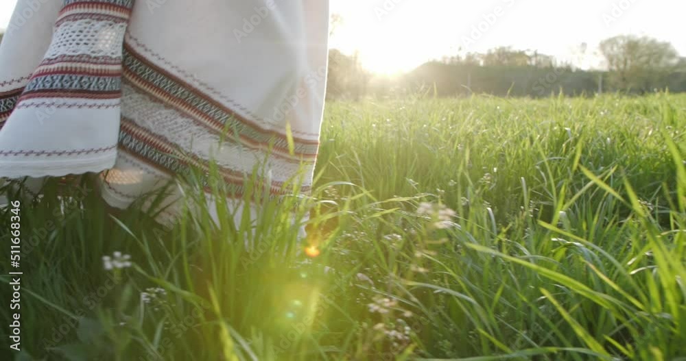 custom made wallpaper toronto digitalA girl in an embroidered dress walks on the grass at sunset. Close-up of legs