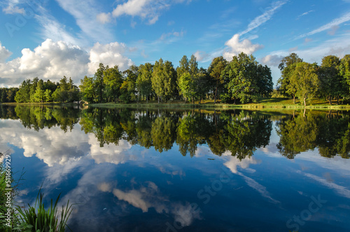 Early autumn, view of the lake with an ancient dilapidated bridge in a cozy wooded park