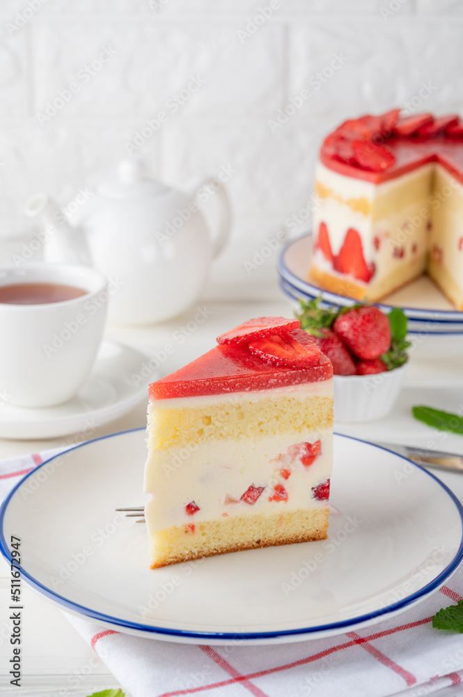 Fraisier mousse cake. Strawberry cake with biscuit, mousse and jelly on a white wooden background. Summer dessert. Selective focus. Copy space. Fraisier mousse cake. Strawberry cake with biscuit, mousse and jelly on a white wooden background. Summer dessert. Selective focus. Copy space.