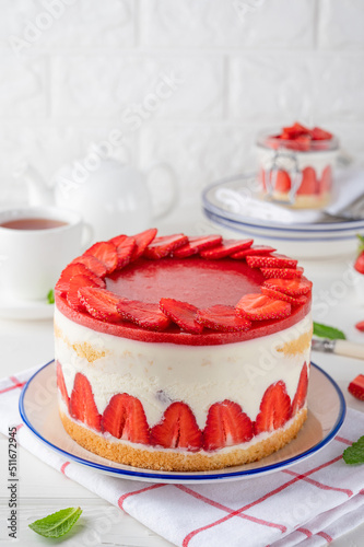 Fraisier mousse cake. Strawberry cake with biscuit, mousse and jelly on a white wooden background. Summer dessert. Selective focus. Copy space.