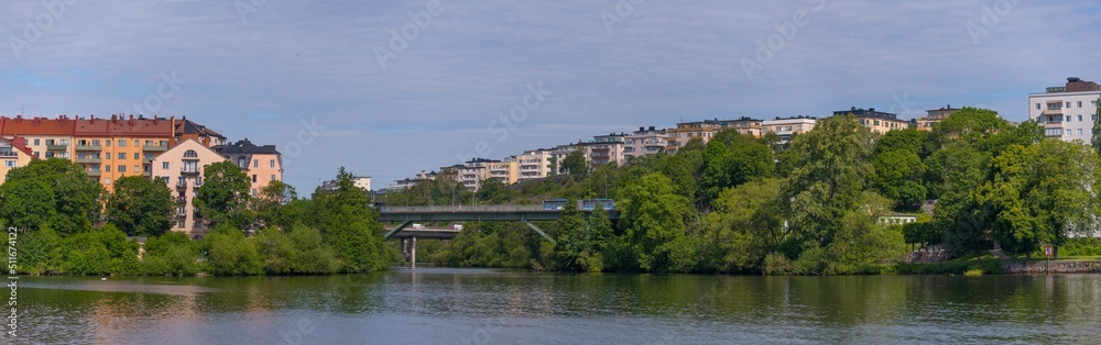 The high way bridge between the island Lilla Essingen and Kungsholmen with water front color full apartment houses a sunny summer day in Stockholm
