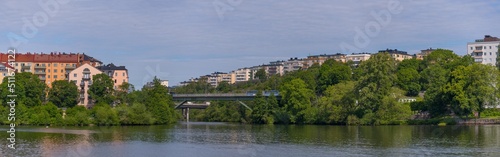 The high way bridge between the island Lilla Essingen and Kungsholmen with water front color full apartment houses a sunny summer day in Stockholm