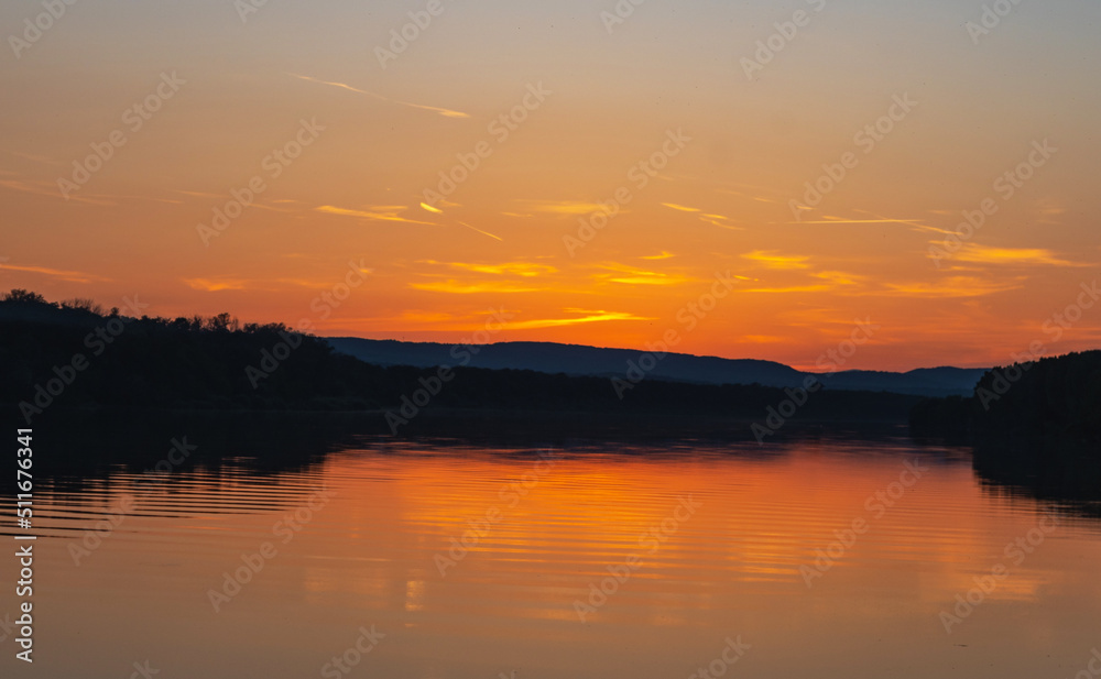 Spectacular sunset on the Danube. Forest, river and a beautiful sunset.