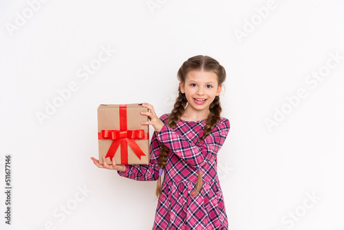 A gift box in the hands of a happy little girl. A birthday present. White isolated background.