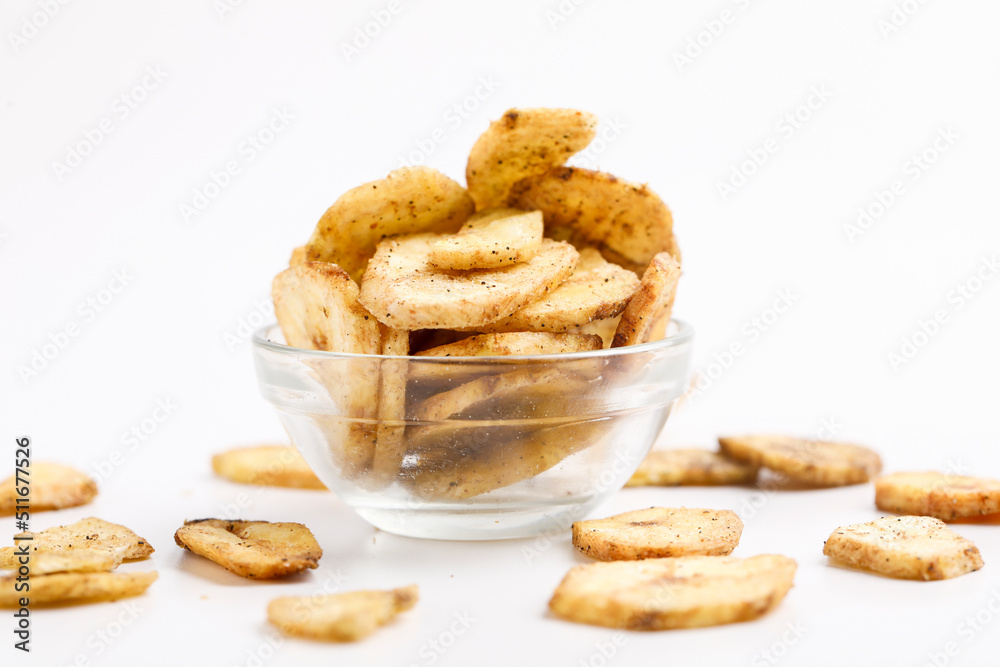 banana chips in bowl on yellow background.