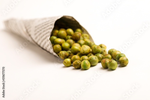 Indian snack, dry spicy green pea in paper cone. photo