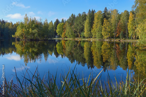 Joutsenlampi in Aulanko nature reserve and recreation area near Hameenlinna city in Finland: autumn, colorful trees, reflection.