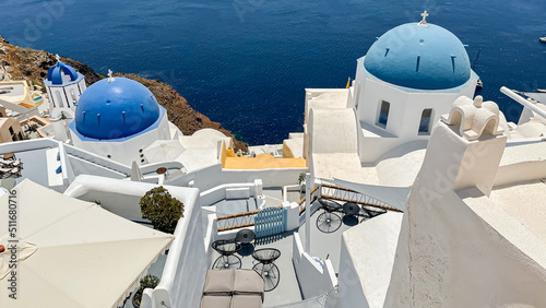 Looking down into the water over patios and blue church domes in iconic Oia on Santorini island