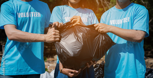 Closeup volunteer holding garbage bag, Man and woman hand picking up garbage plastic for cleaning at park.