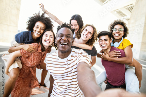 Multiracial friends taking selfie group picture with smart mobile phone outside on city street - Happy young people smiling together looking at camera - Youth lifestyle concept with teens hanging out