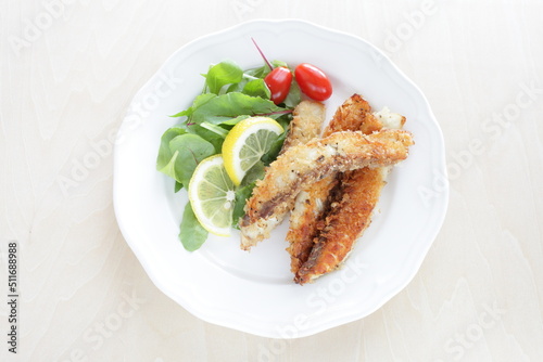 Homemade bread crumbs sardines fillet fried served with baby leaves and cherry tomato